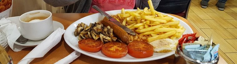 Full English breakfast with sausage, mushrooms, chips, tomato and beans